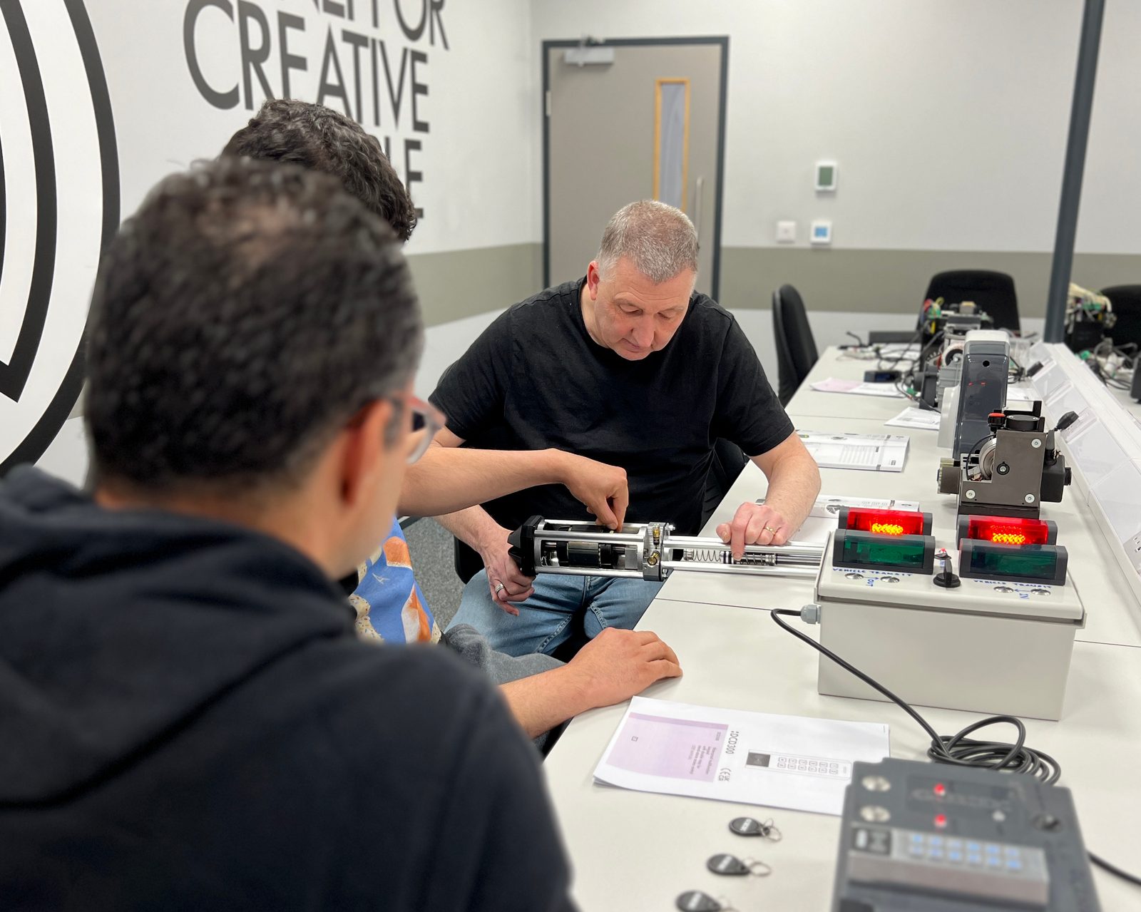Installers learning GIBIDI gate motor wiring and set-up at a UK training session